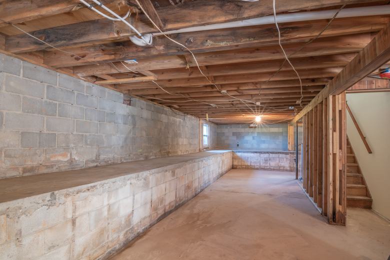 Sous-sol aux murs en parpaings et aux solives apparentes
